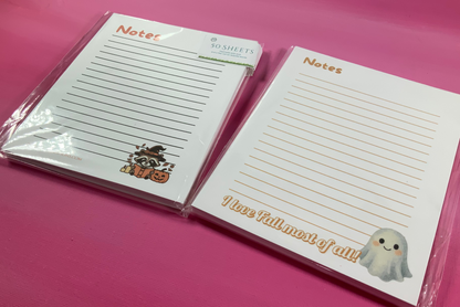 Two Halloween-themed notepads with cartoon characters on a pink background