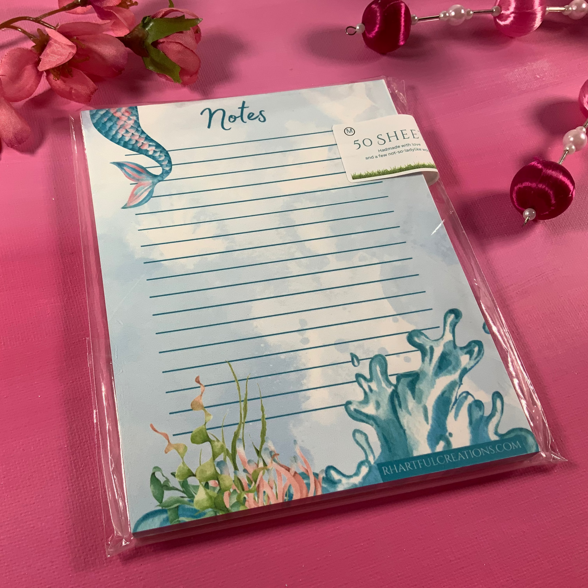 Notepad with underwater design on a pink background with flowers