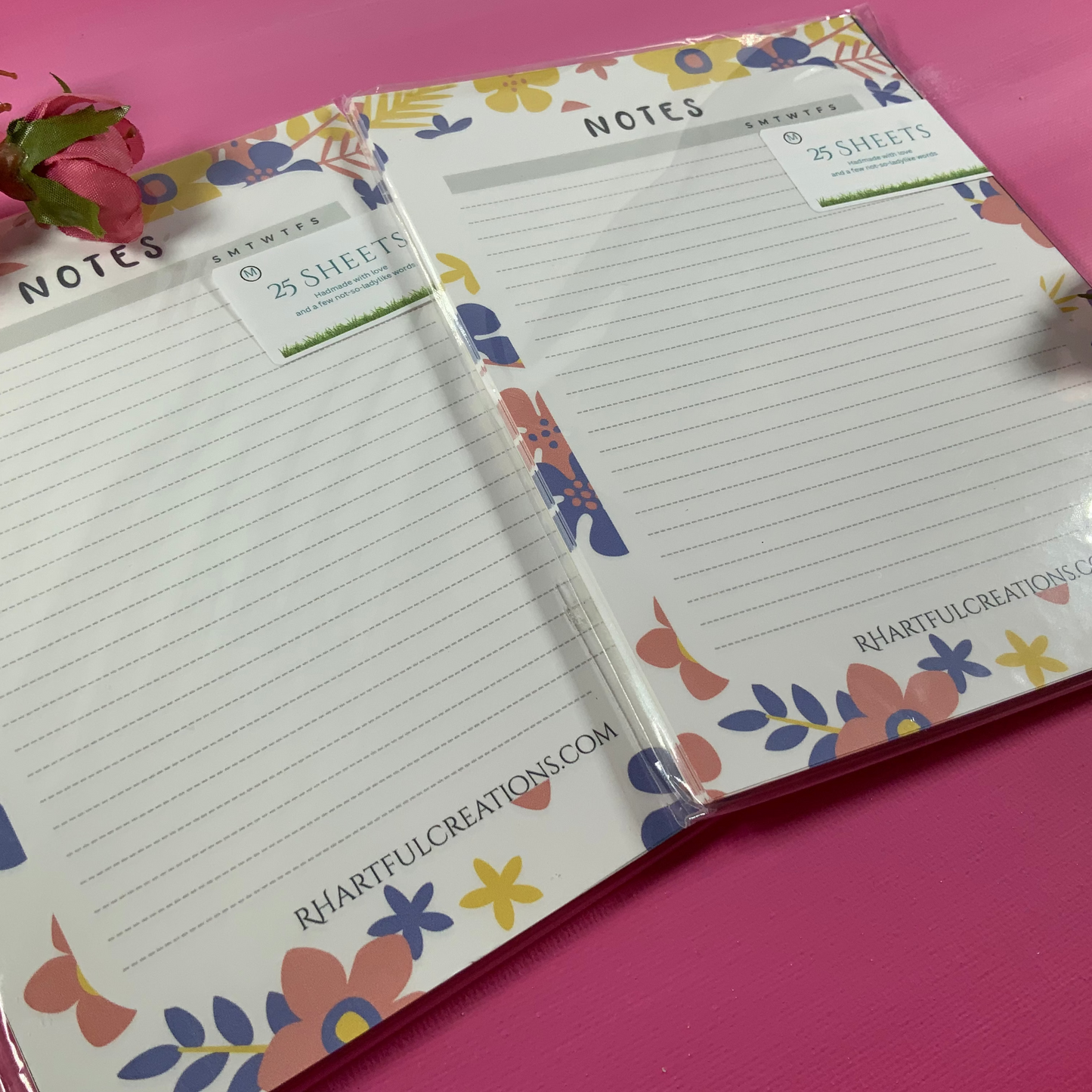 Floral notebook with lined pages on a pink background
