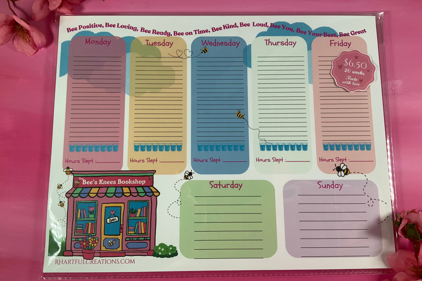 Weekly planner pad with days of the week on a pink background