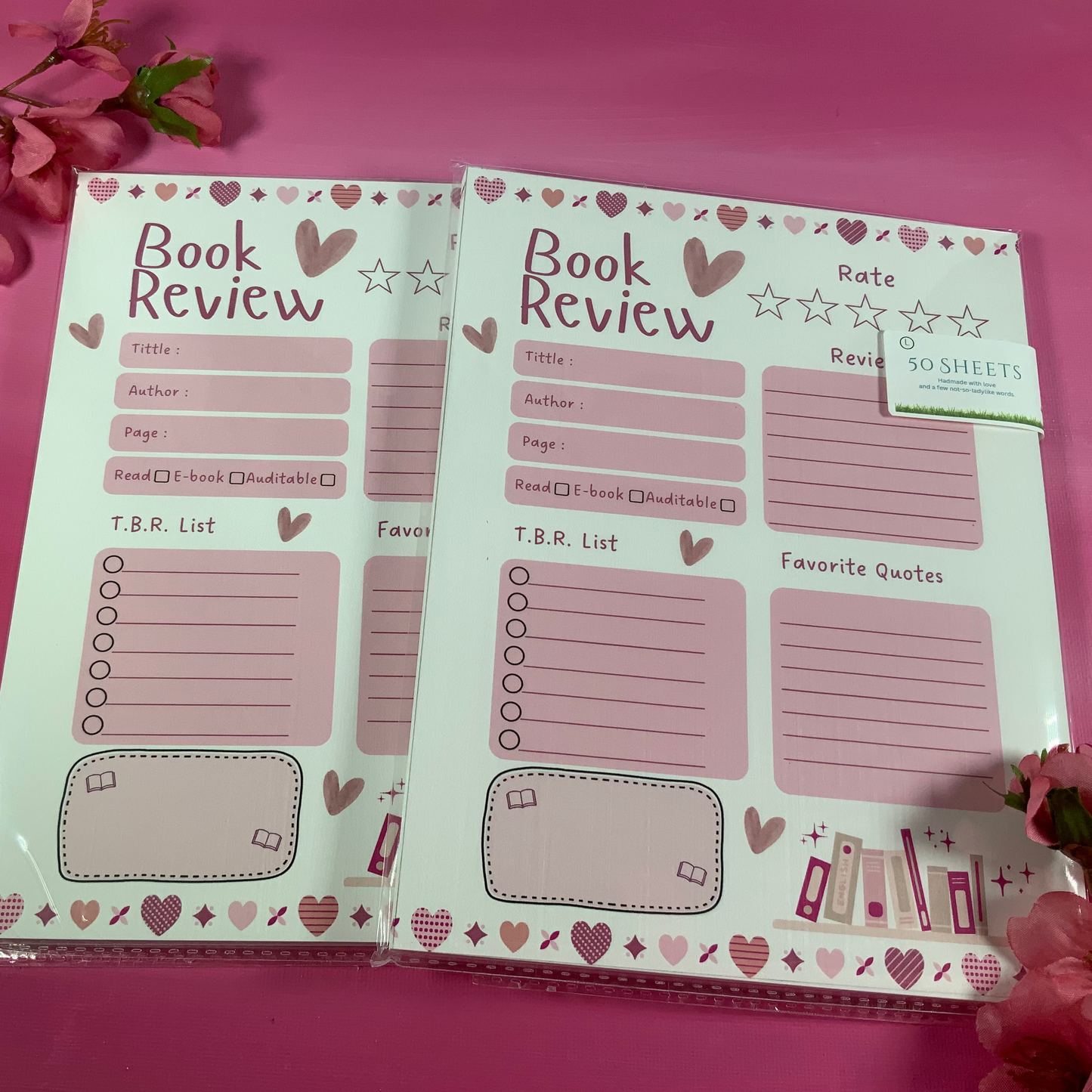 Two book review pads with heart and star designs on a pink background.