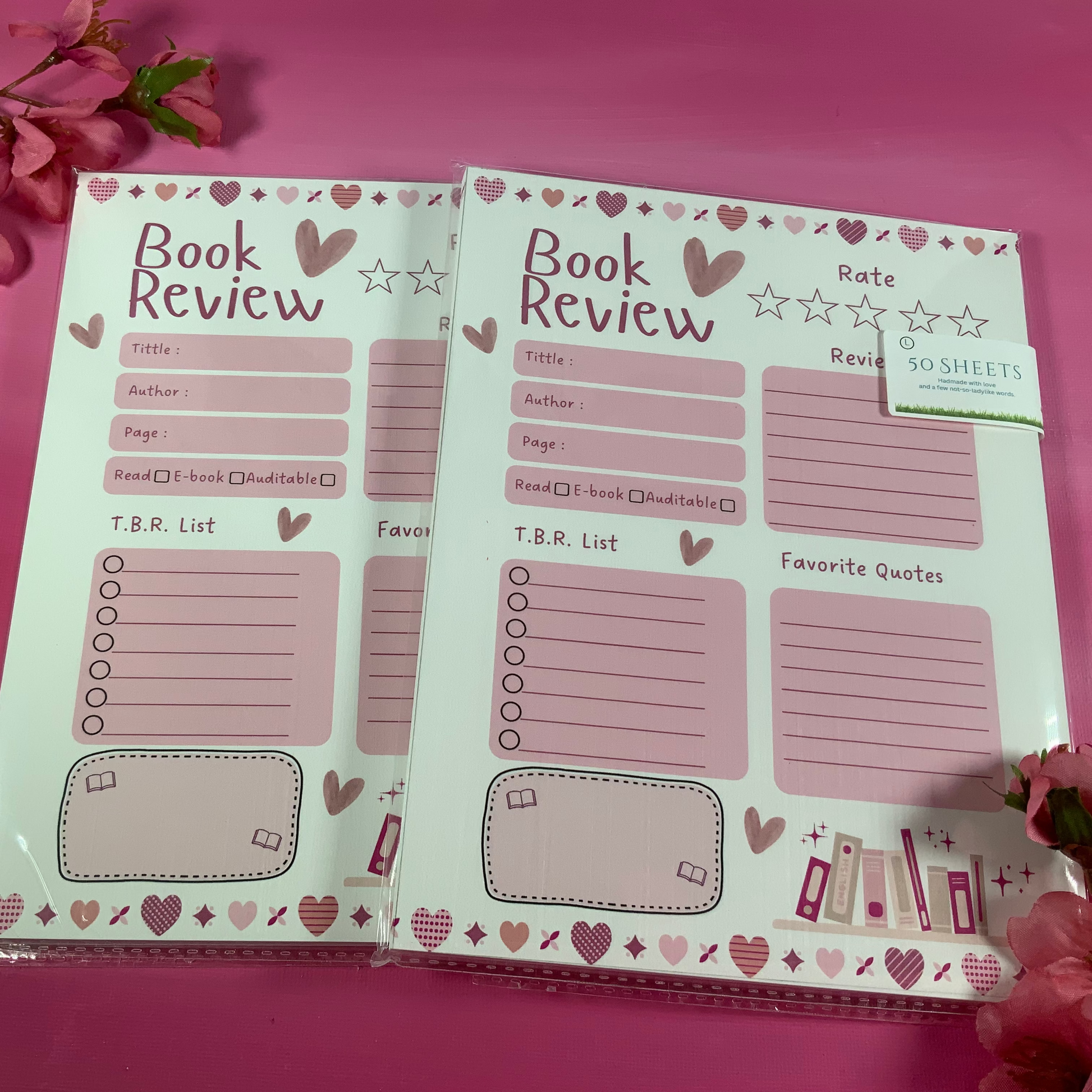 Two book review pads with heart and star designs on a pink background.