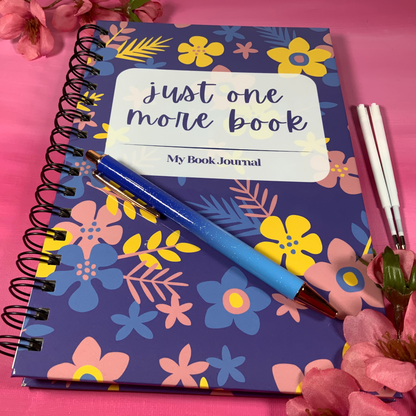 Floral notebook with a pen on a pink background