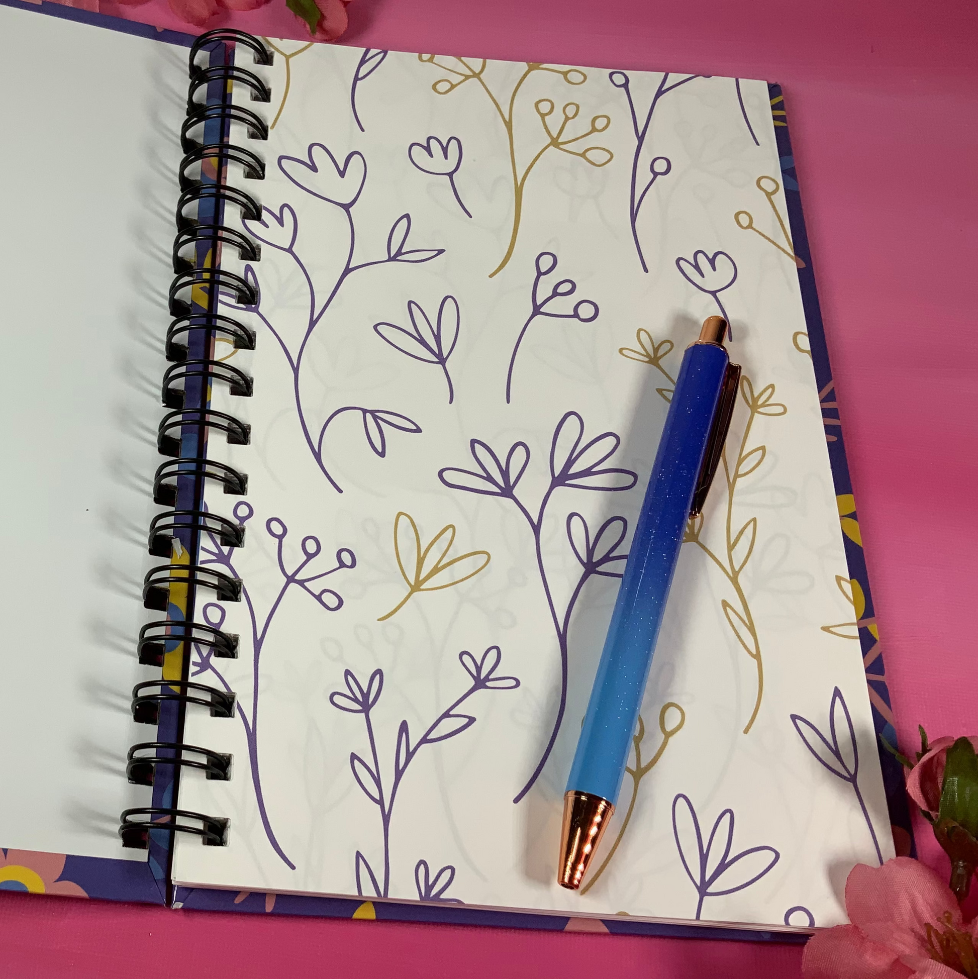 Open notebook with floral pattern on pink background