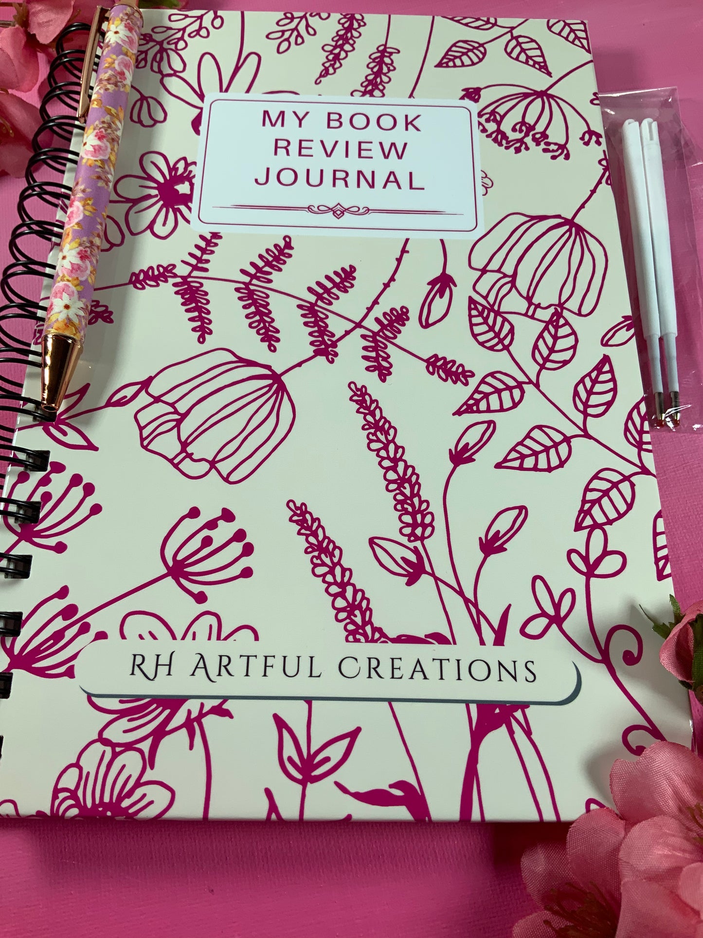 Book review journal with floral design and 'RH Artful Creations' branding on a pink background.