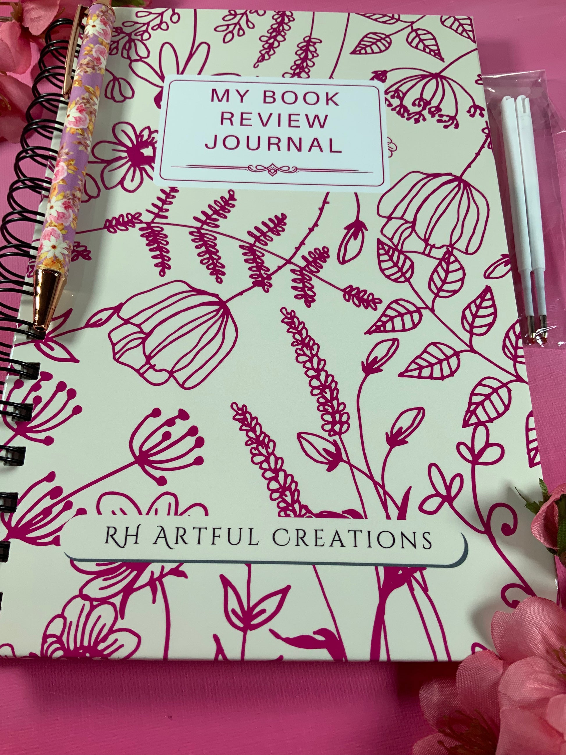Book review journal with floral design and 'RH Artful Creations' branding on a pink background.