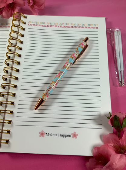 Notebook with a floral pen on a pink background