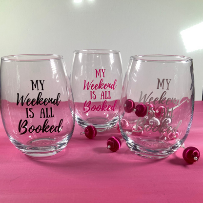 Three clear glasses with 'My Weekend is All Booked' text on a pink surface.