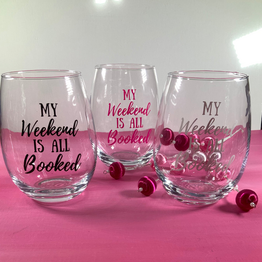 Three clear glasses with 'My Weekend is All Booked' text on a pink surface.