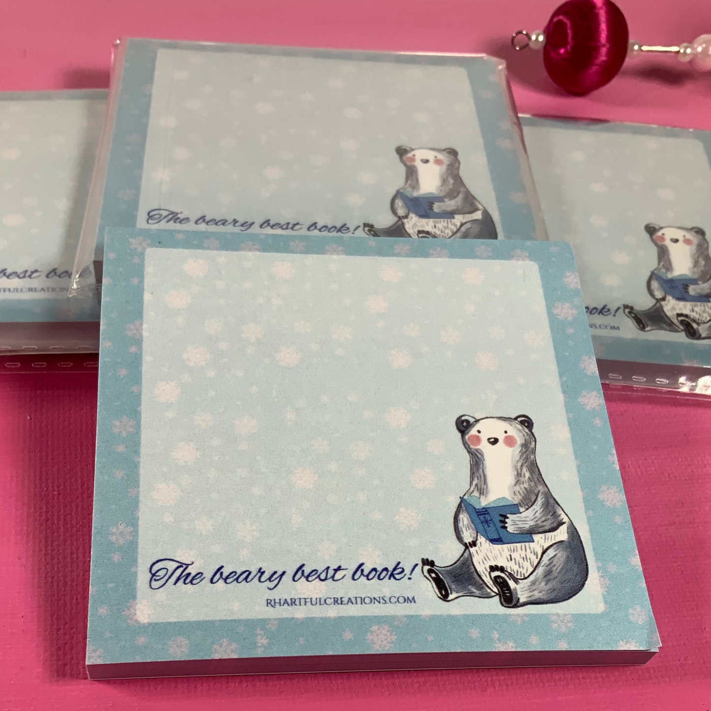 Notebook with bear illustration and text on a pink surface