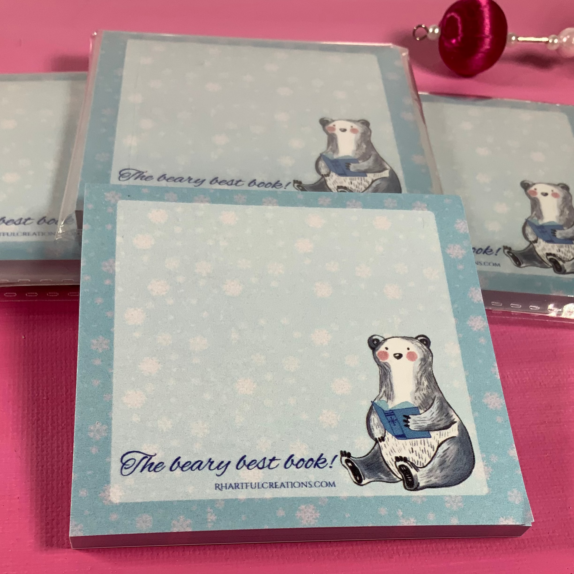 Notebook with bear illustration and text on a pink surface