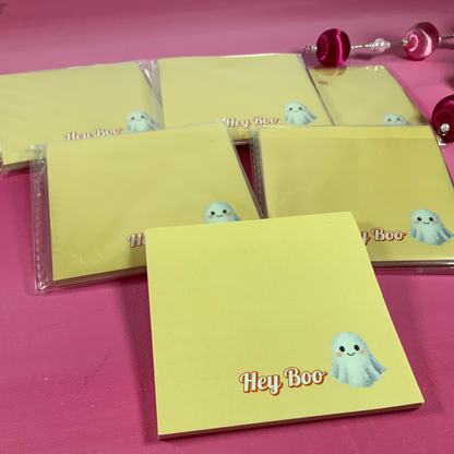 Yellow notepads with 'Hey Boo' design on a pink surface