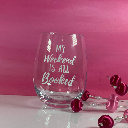 Stemless wine glass with 'My Weekend is All Booked' text on a pink background