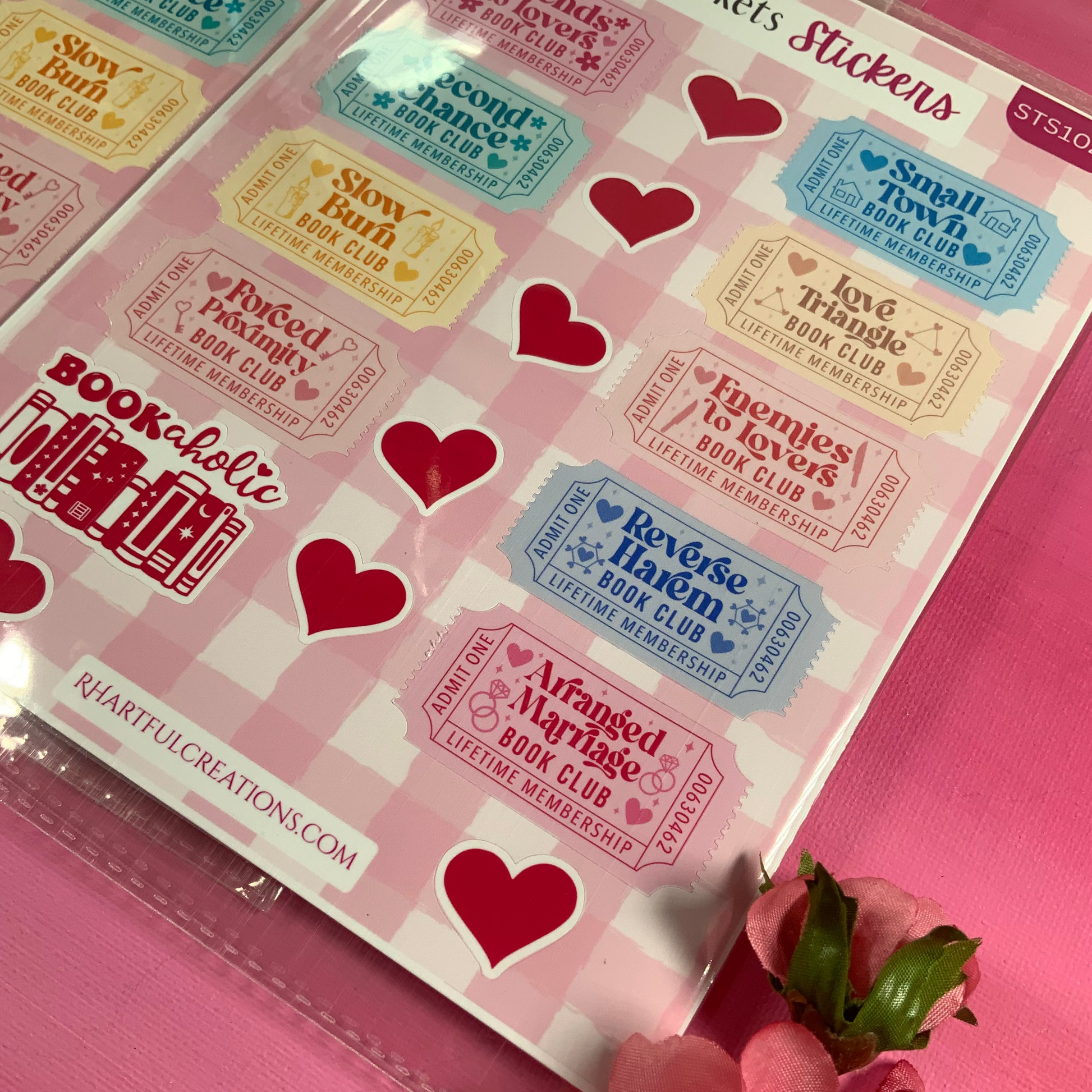Sheet of stickers with heart designs and text on a pink background with flowers.