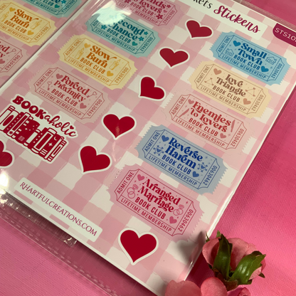 Sheet of stickers with heart designs and text on a pink background with flowers.