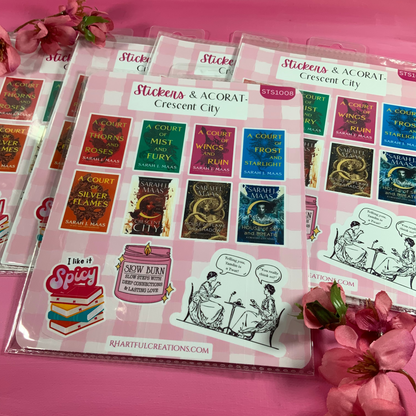 Sticker sheets with book-themed designs on a pink surface with flowers.