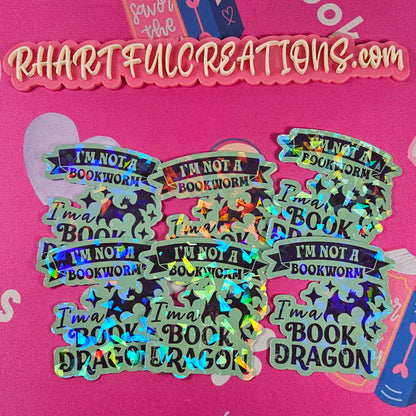 “I’m Not a Bookworm, I’m a Book Dragon” holographic vinyl sticker with rainbow sparkle finish, handmade by RH Artful Creations.