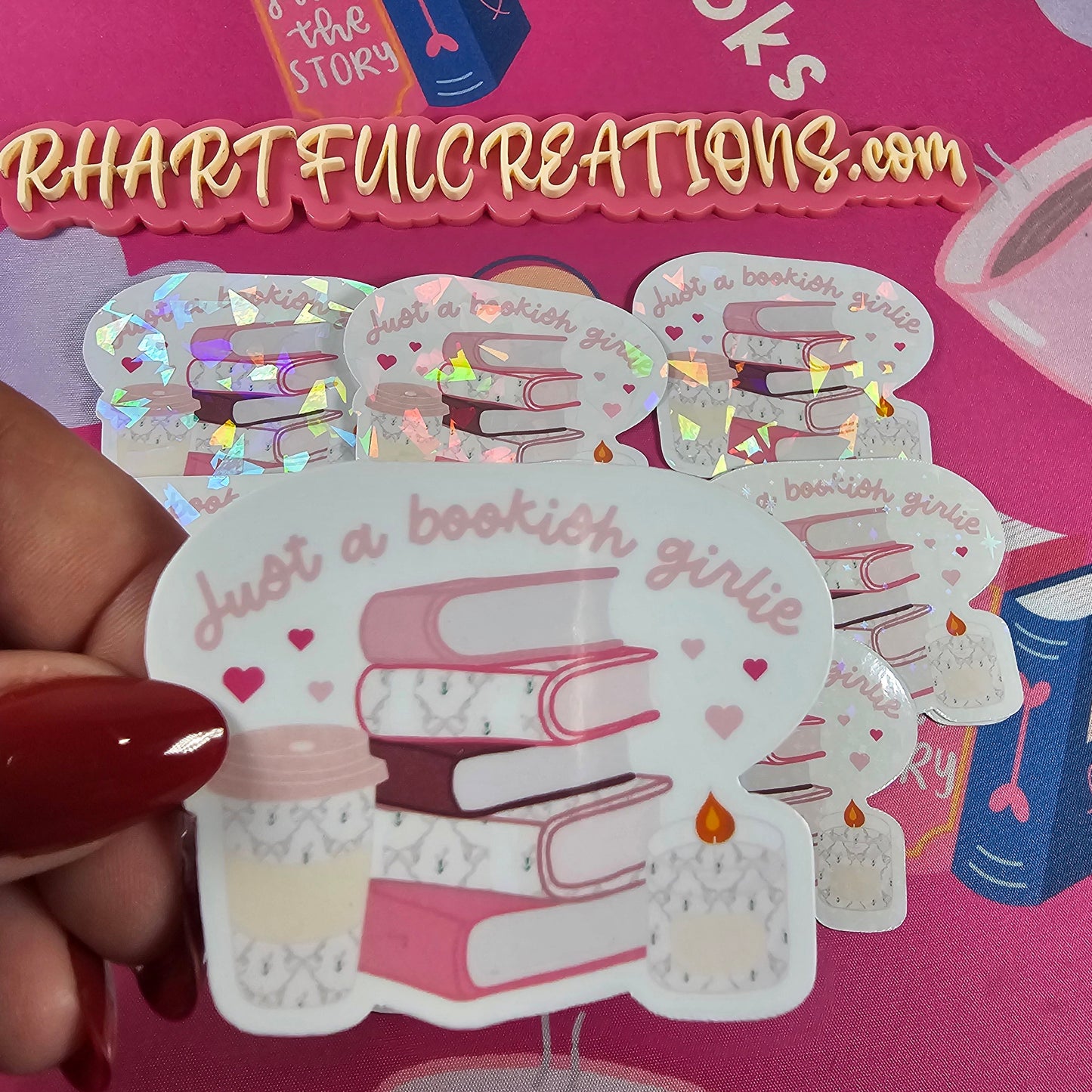 “Just a Bookish Girlie” sticker with pink stacked books, coffee cup, and candle — handmade by RH Artful Creations for book lovers.