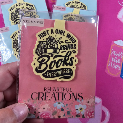 Pink book with decorative elements and 'Girl Who Reads' stickers on a pink background
