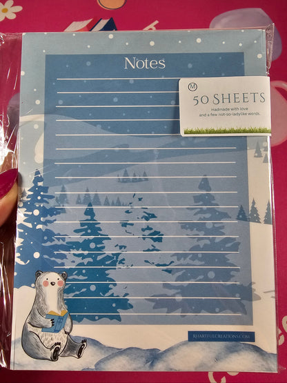Packaged notebook with a winter design on a pink background