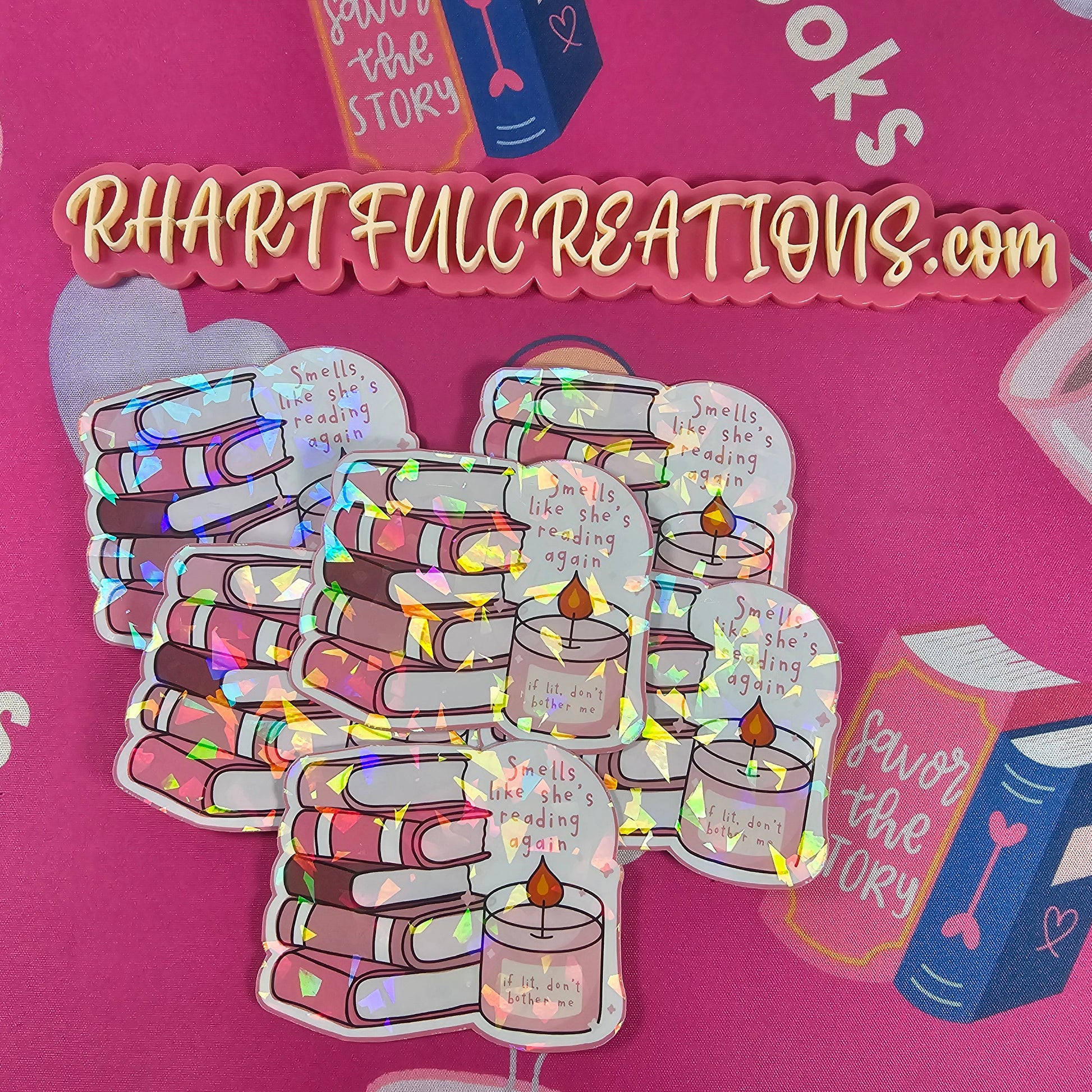 Holographic sticker of pink book stack with candle reading “if lit, don’t bother me” and text “Smells like she’s reading again,” handmade by RH Artful Creations.