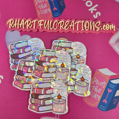 Holographic sticker of pink book stack with candle reading “if lit, don’t bother me” and text “Smells like she’s reading again,” handmade by RH Artful Creations.